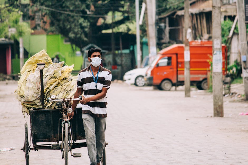 Manual labor worker pushing cart during pandemic